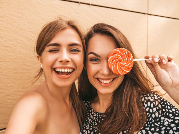 Two young smiling hipster women in summer clothes.