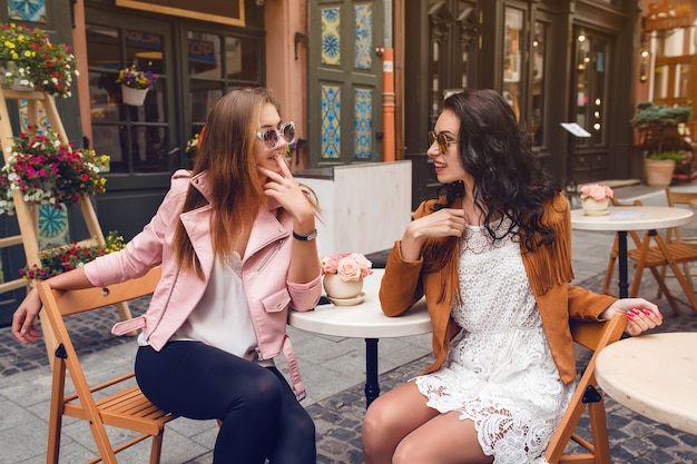 Two young stylish women sitting at cafe