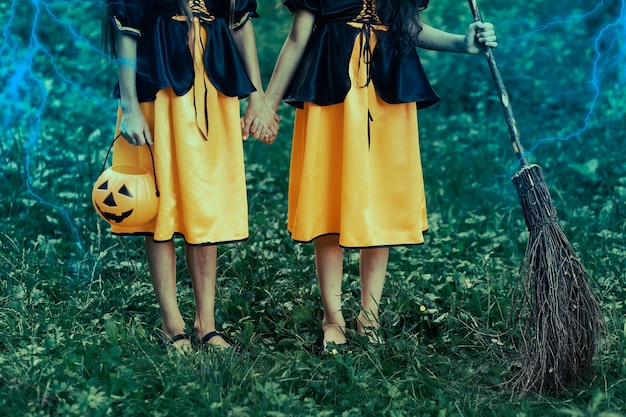 Free Photo two young witches in forest on halloween