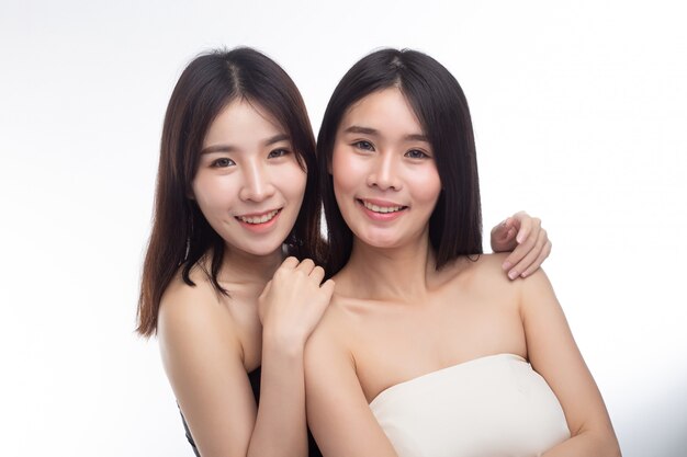 Two young women happily stood together from behind.