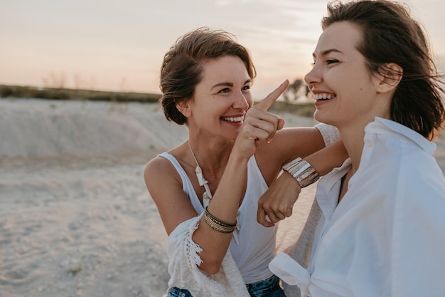 Two young women having fun on the sunset beach