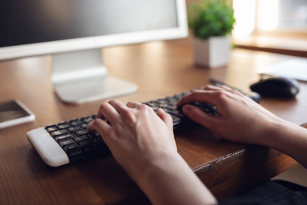 Free Photo typing text, close up. caucasian young woman in business attire working in office