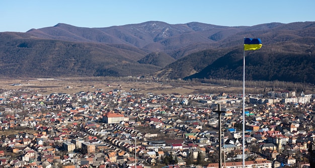 Ukrainian flag and cross on the background of mountains