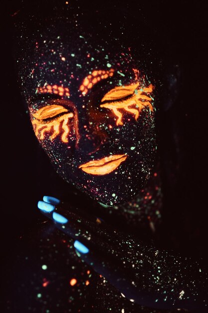 Ultraviolet make-up. Portrait of a girl painted in fluorescent powder. Halloween concept. Galaxy asleep.