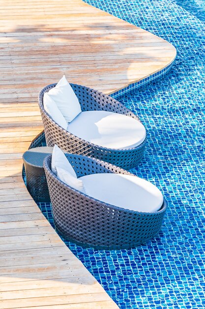 Umbrella and chair around outdoor swimming pool in hotel resort with sea ocean view for travel vacation