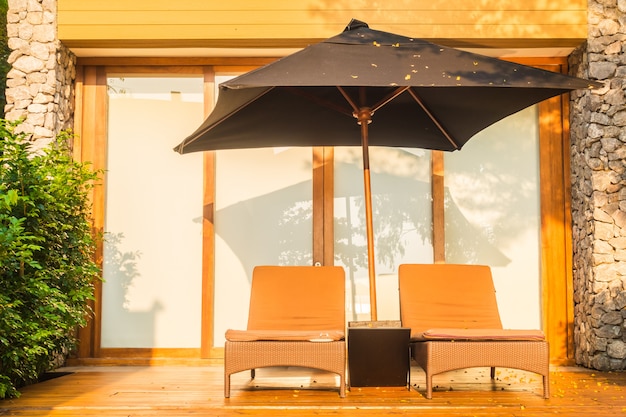 Umbrella and chair around swimming pool