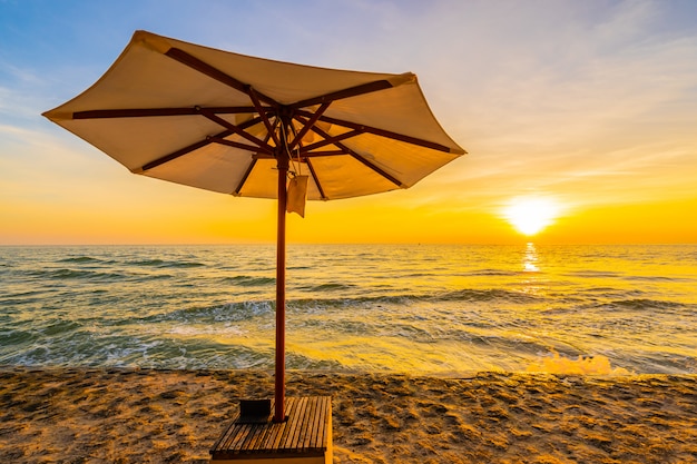 Umbrella and chair with pillow around beautiful landscape of beach and sea