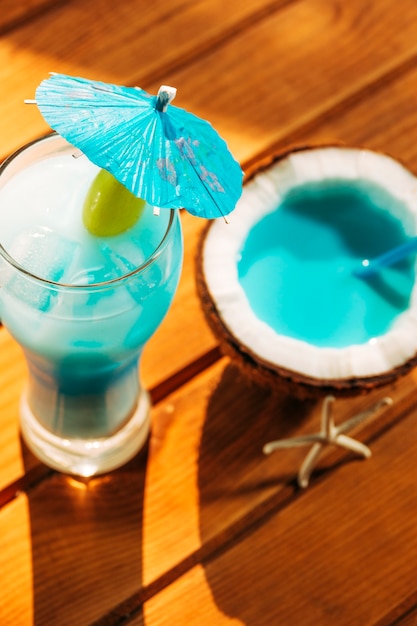 Umbrella decorated glass and cracked coconut with bright blue drink 