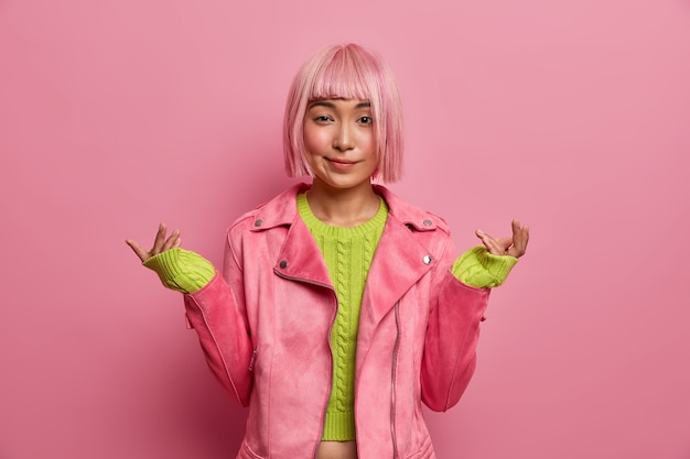 Free Photo unaware hesitant woman with pink bob hairstyle raises hands in bewilderment, has no idea what happening