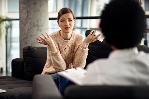 Free Photo uncertain woman communicating with her psychotherapist at doctor's office