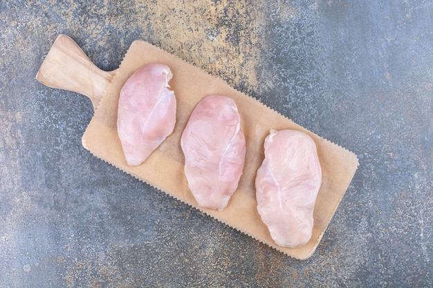 Free Photo uncooked chicken breasts on wooden board. high quality photo