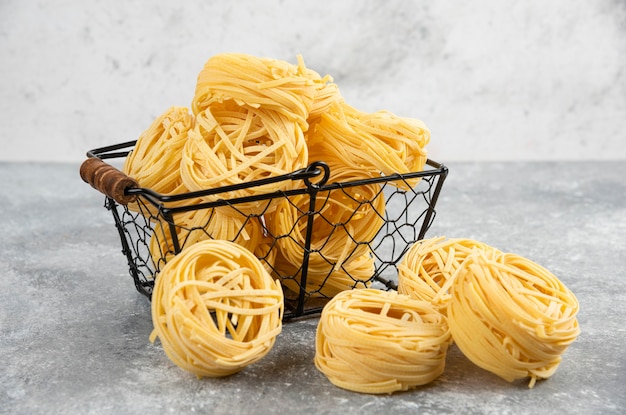 Uncooked noodle rolls in a metallic tray.