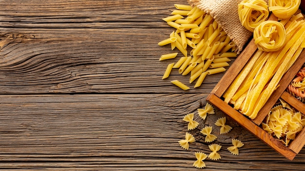 Uncooked pasta mix in wooden box on table