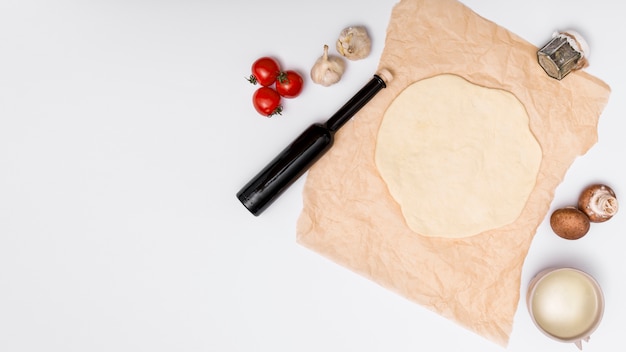 Uncooked pizza ingredient and rolled pizza dough isolated on white backdrop