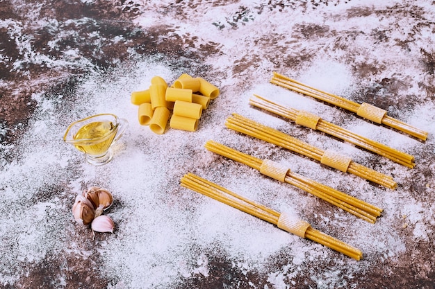 Uncooked raw spaghetti and macaroni on wooden kitchen table. 