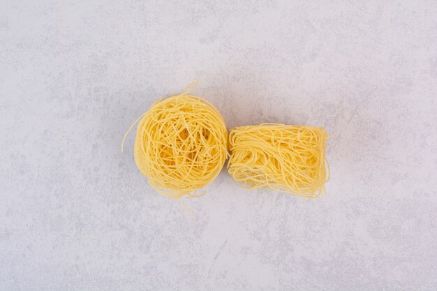 Uncooked spaghetti nests on stone surface