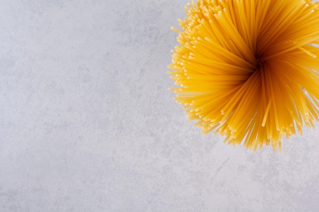 Free photo uncooked yellow spaghetti on marble table.