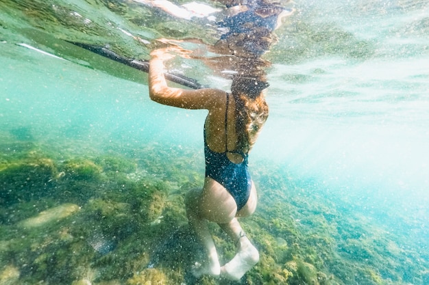 Free photo underwater shot of woman with surfboard