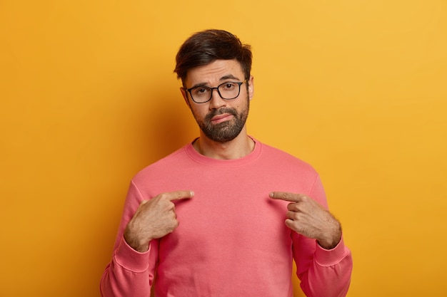 Free Photo unimpressed tired man points at himeself, shows his new pink jumper