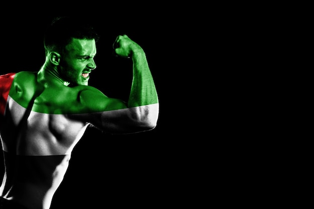 United Arab Emirates flag on handsome young muscular man black background