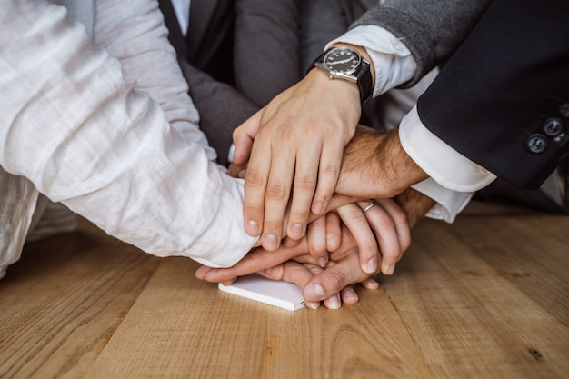 Free photo united hands of business team on workspace background