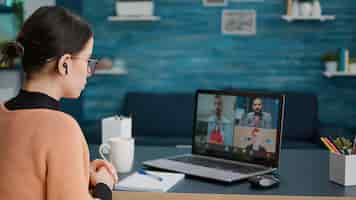 Free photo university student attending video call meeting with people on online school class, using laptop at home. woman having conversation on remote teleconference, webinar learning chat.