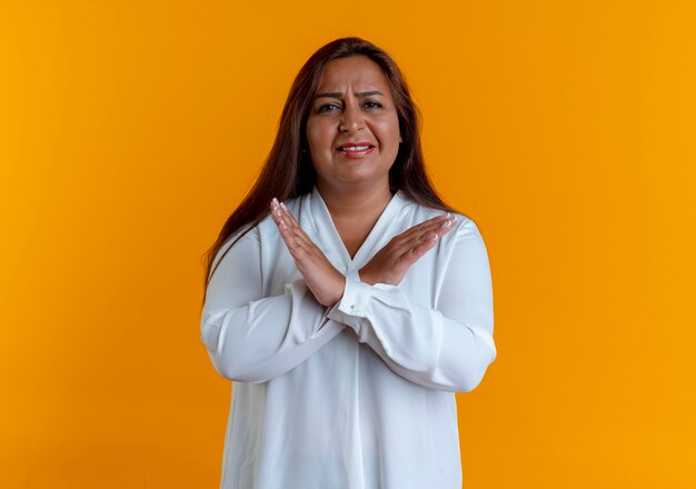 Unpleased casual caucasian middle-aged woman showing gesture of no isolated on yellow wall