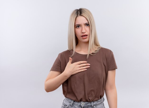 Unpleased young blonde girl with hand on chest on isolated white wall with copy space