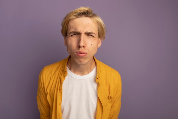 Free photo unpleased young blonde guy wearing yellow t-shirt