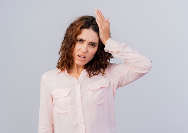 Unpleased young caucasian woman puts hand on head