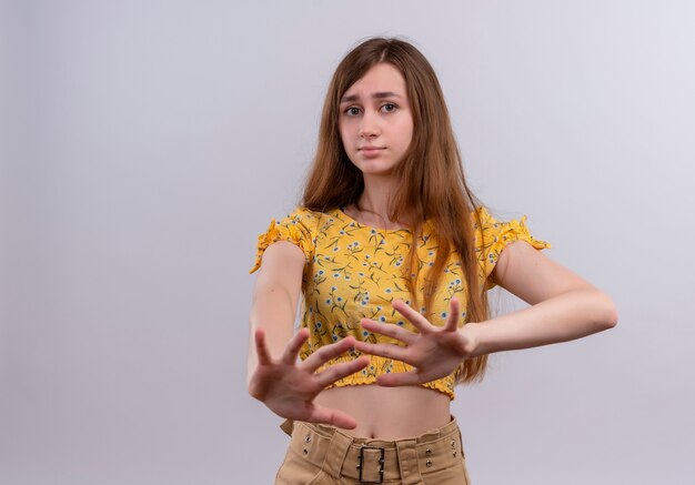 Unpleased young girl stretching hands  on isolated white wall with copy space