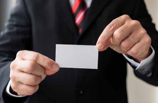 Free photo unrecognisable man holding blank business card