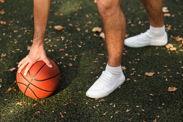 Free photo unrecognisable man playing basketball in nature