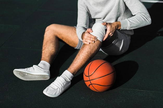 Unrecognisable player applying bandage on knee