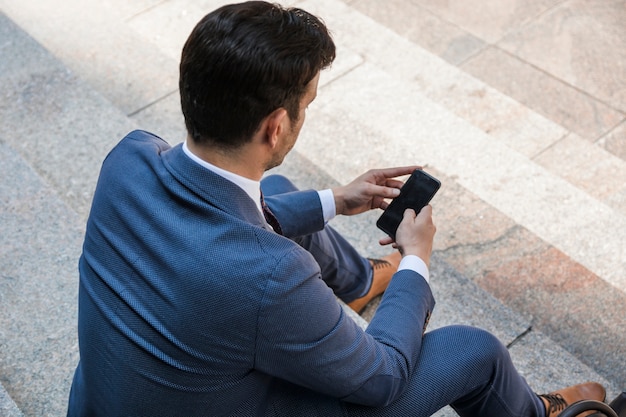 Unrecognizable businessman using smartphone