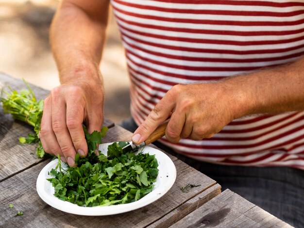 Unrecognizable cook cutting celery for salad