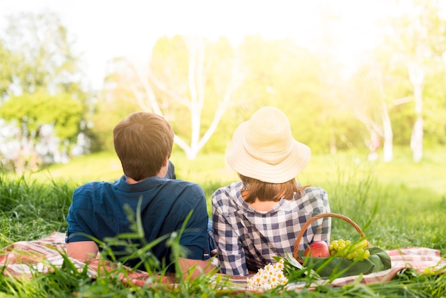 Unrecognizable couple lying on plaid in forest