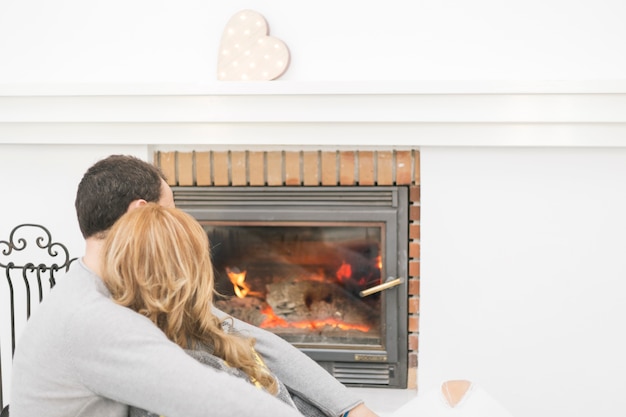 Free photo unrecognizable couple near fireplace