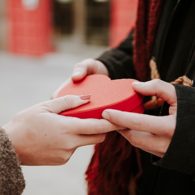 Free photo unrecognizable couple with heart gift