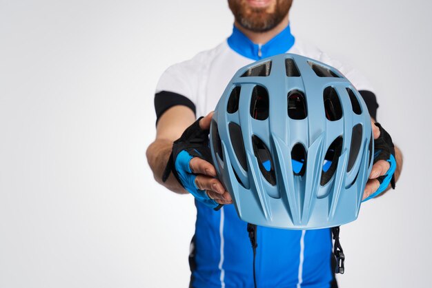 Unrecognizable cyclist demonstrating modern protective helmet to camera