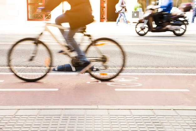 Unrecognizable cyclist riding a bike on bicycle lane through city street