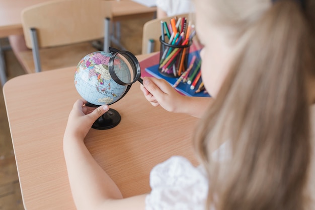 Free Photo unrecognizable girl examining globe