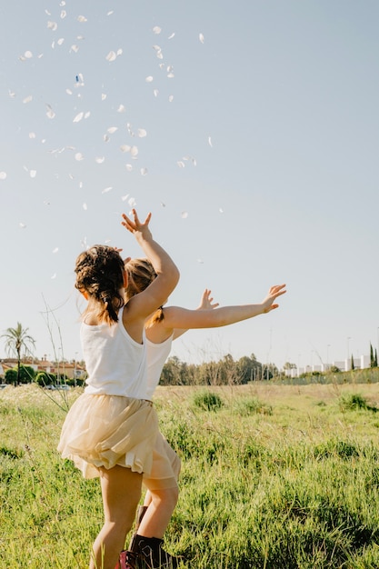 Free photo unrecognizable girls trying to catch petals