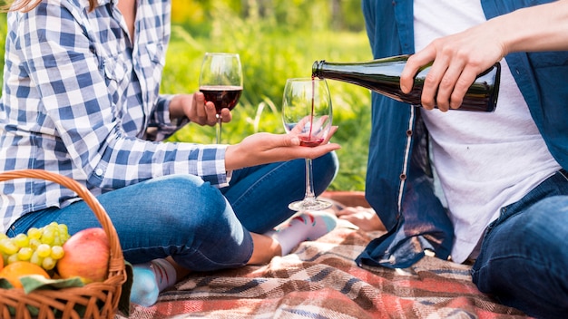 Unrecognizable man pouring wine into glasses during date