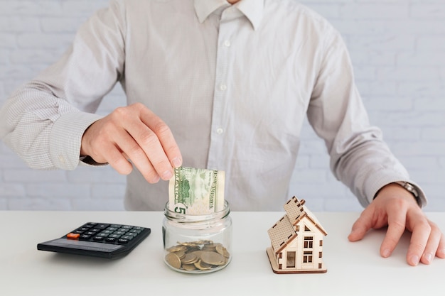 Free photo unrecognizable man putting money to jar