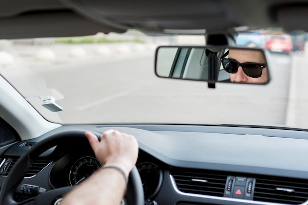 Free photo unrecognizable man riding in car on busy road