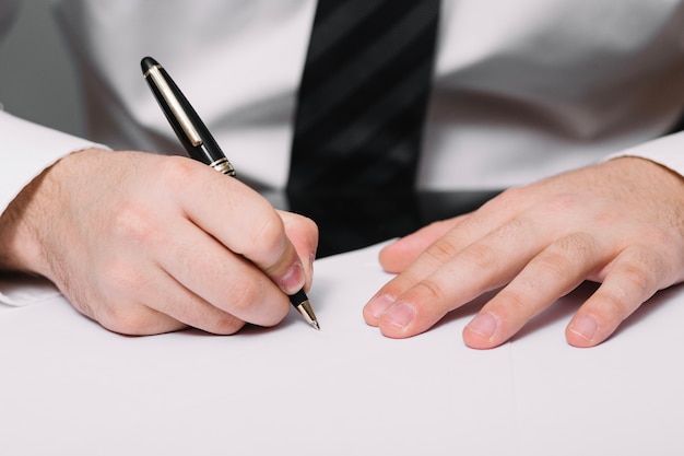 Free photo unrecognizable man writing in office