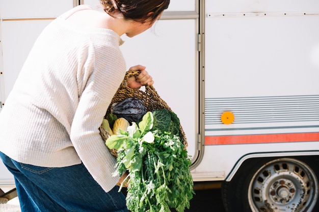 Free photo unrecognizable woman trying to carry basket