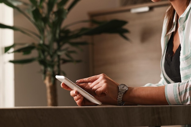 Free Photo unrecognizable woman using digital tablet and surfing the net while relaxing at home