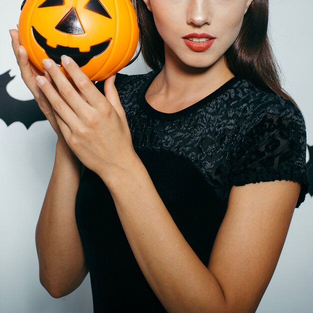 Unrecognizable woman with pumpkin